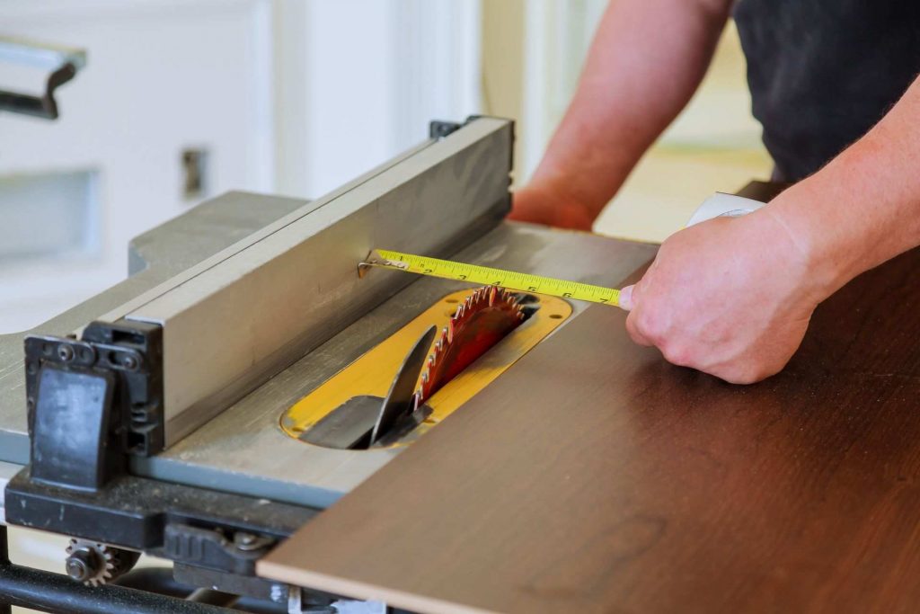 carpenter using table saw to cut plywood